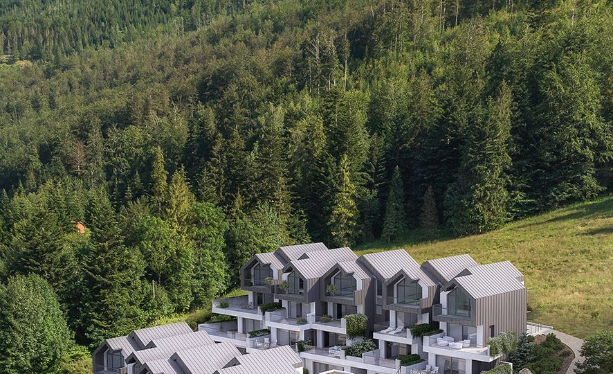 A visualization of a scenic residential complex featuring modern mountain multi-family buildings situated on a slope.